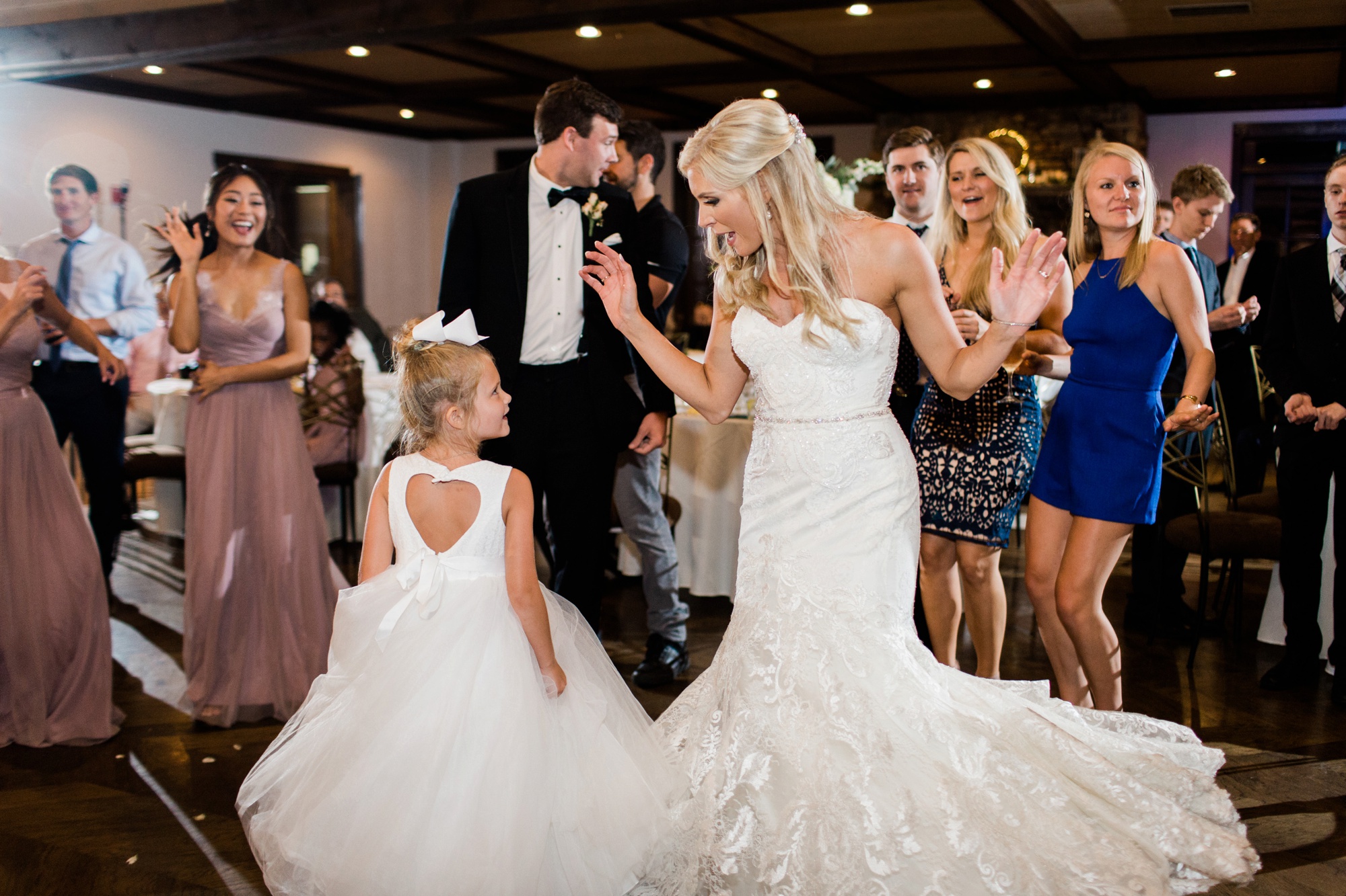 Luxury destination wedding photographer Rebecca Cerasani photographs bride dancing with her flower girl