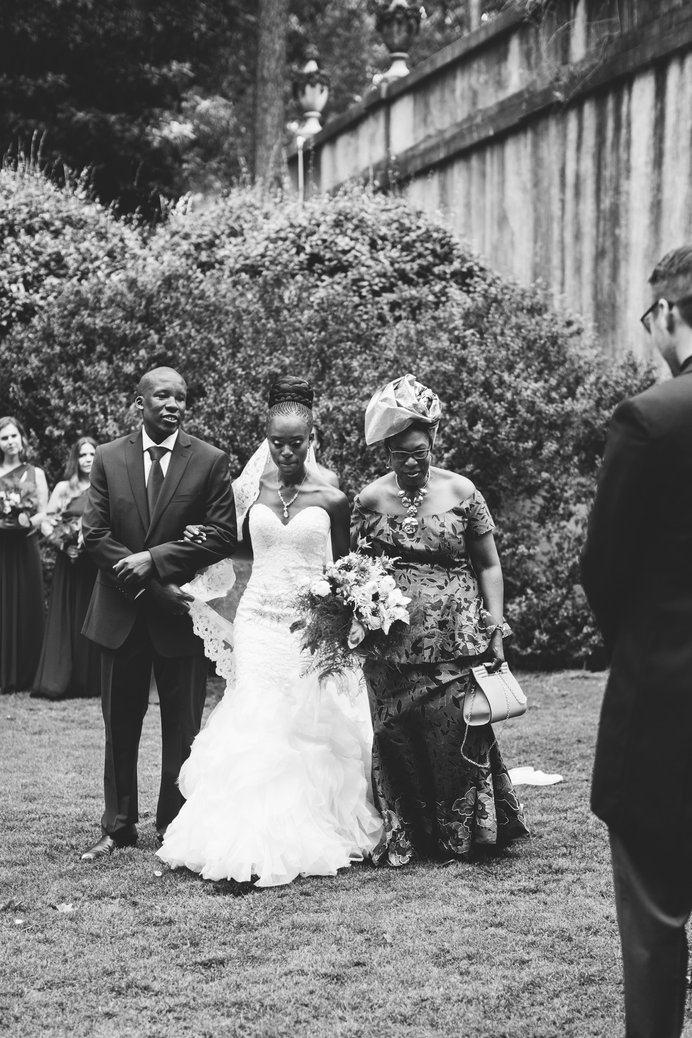 An emotional bride led by her mother and brother approaches her groom. Real wedding moment captured by Rebecca Cerasani