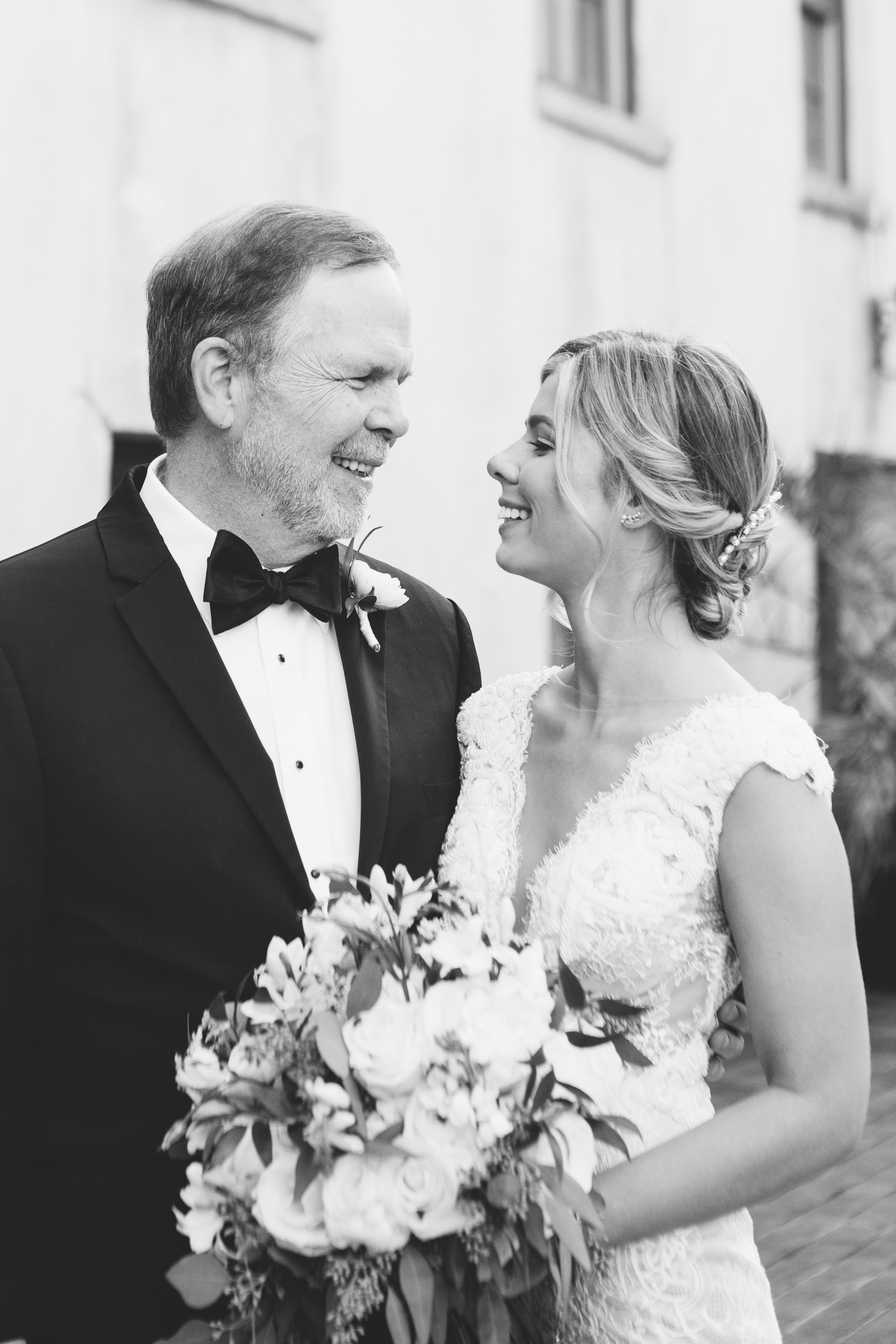 A bride and her dad share a sweet moment during family portraits. Photo by Rebecca Cerasani.