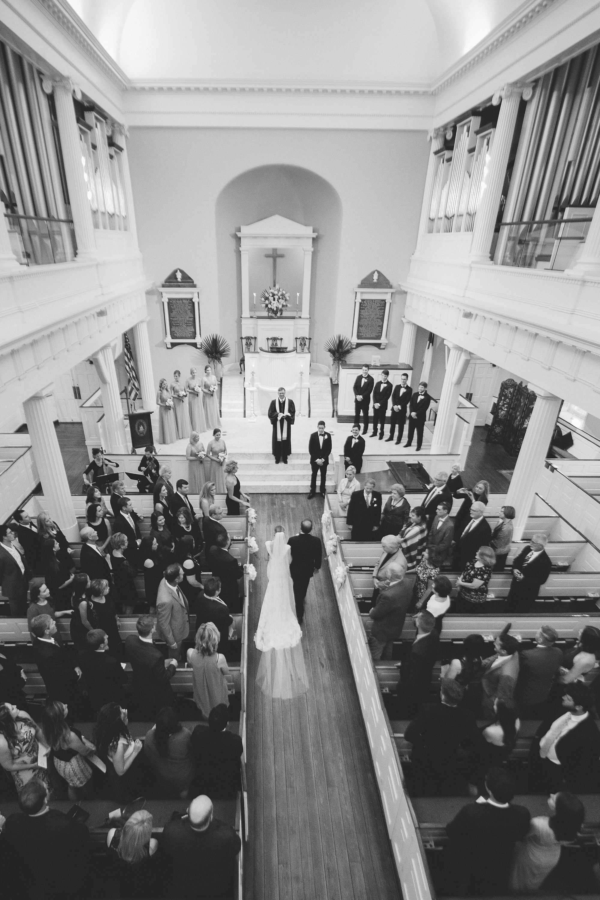 Bride walking down the aisle at First Baptist Church of Charleston. First Baptist Church of Charleston. Pink and teal romantic wedding in Historic Charleston, South Carolina by top Wedding Photographers Leigh and Becca.