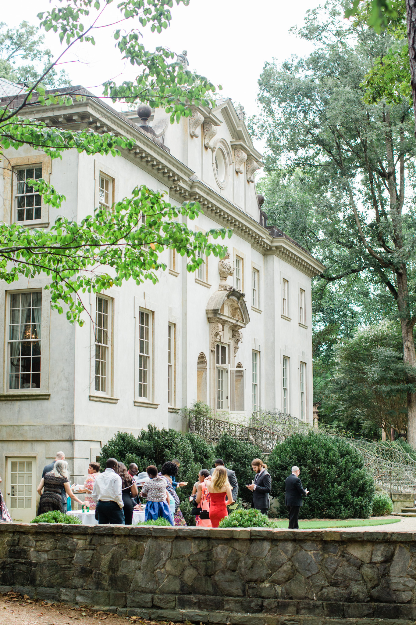 Guests arrive at the Swan House for an outdoor wedding celebration. Event captured by Rebecca Cerasani
