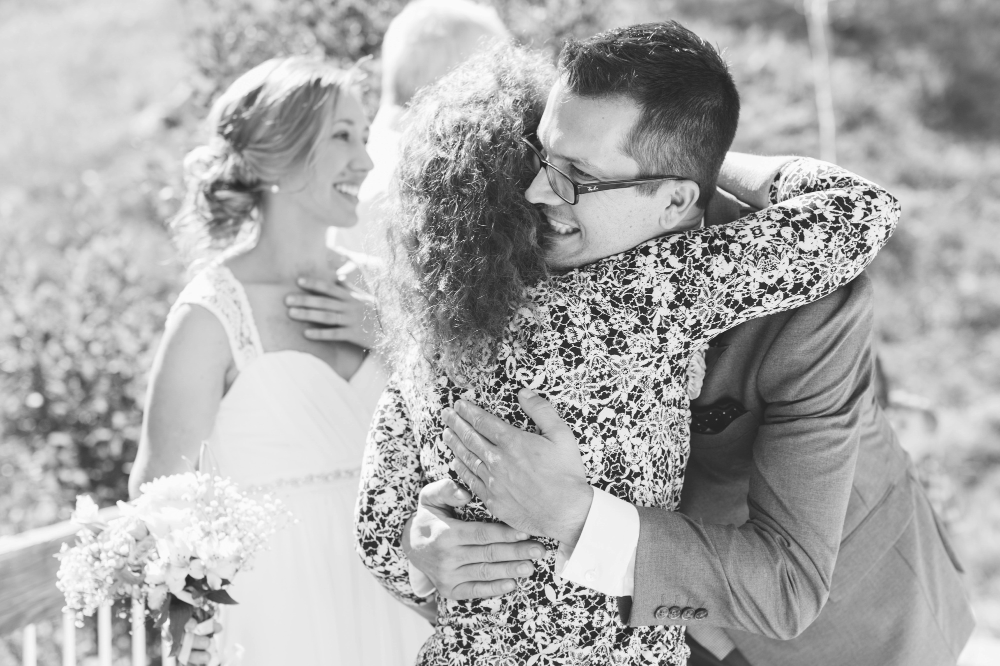Mother of the groom hugs tight just after wedding ceremony. Love, joy, and bliss as bride and groom spend time having wedding photos taken. Photo by destination wedding photographer Rebecca Cerasani.
