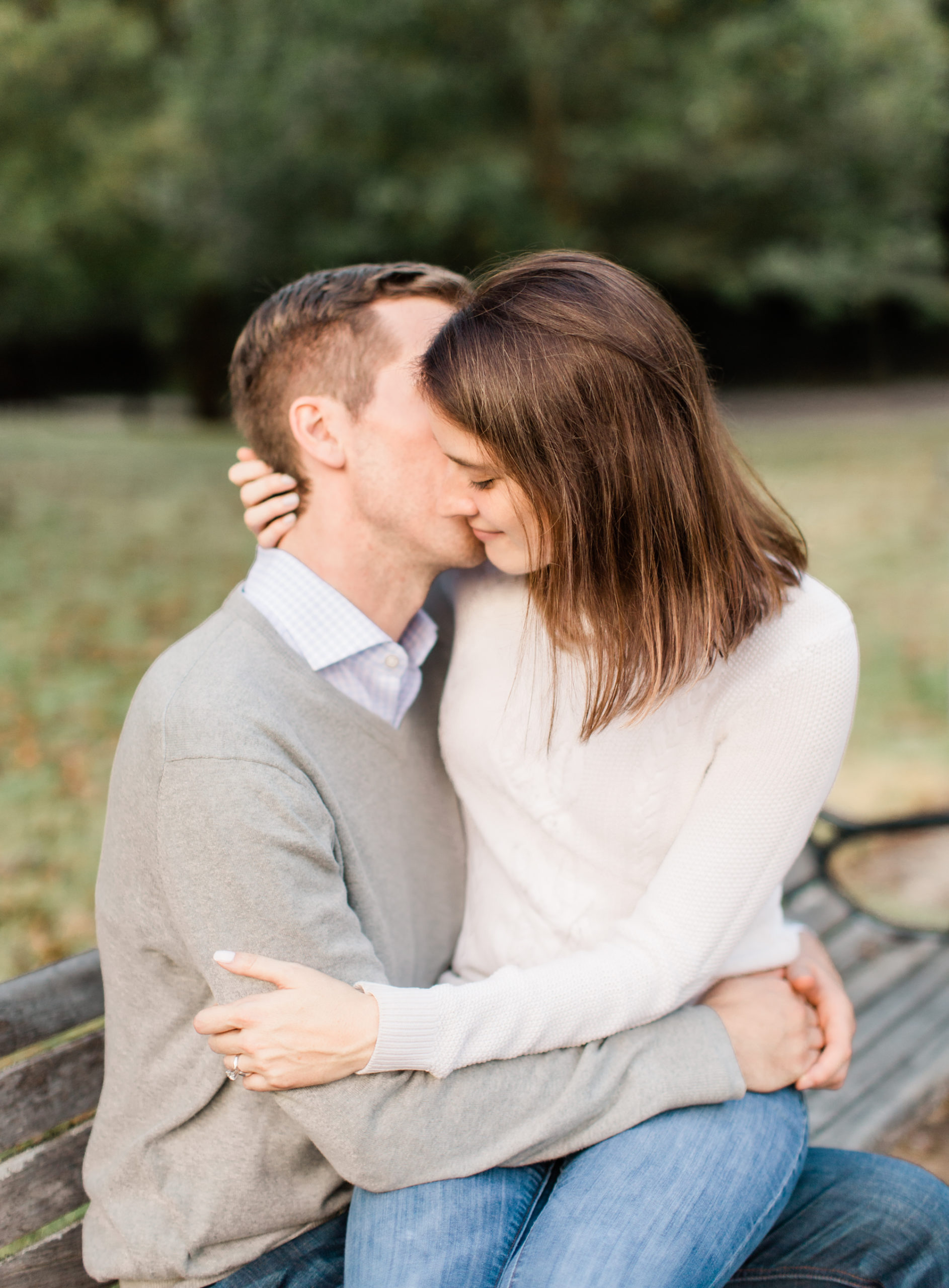 Engaged couple embrace on Piedmont park bench